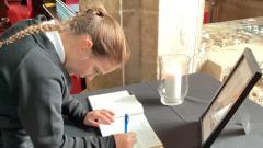 Child signing the book of condolence 