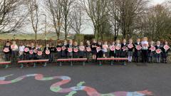 Class 2 Children lined up holding paper plate poppies