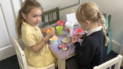 Girls playing in toy kitchen