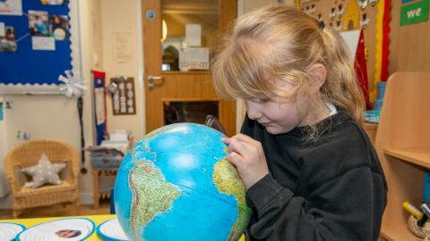 Young pupil studying a globe