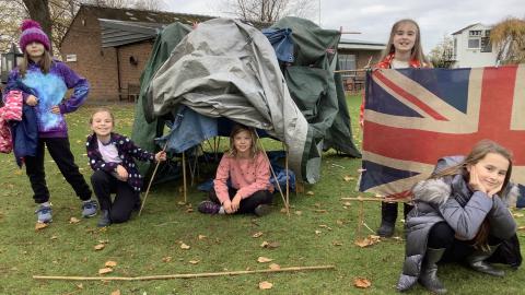 A group of girls from class 3 proudly showing off their newly built den