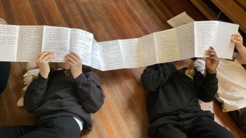 Class 3 pupils reading some of Daniel Ingram browns notes from his first draft of Beas witch 