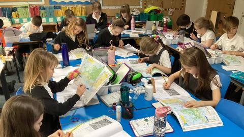 Class 3 using atlases in their Geography lesson