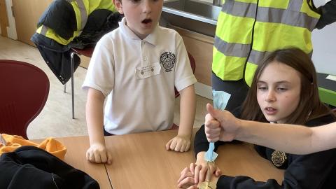Two children looking in awe at how much weight a plastic bag can hold during an experiment set up