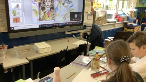 children sat at desk painting