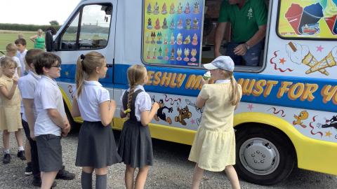 Children wait beside an ice cream van