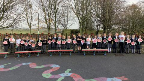 Class 2 Children lined up holding paper plate poppies