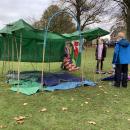 Girls discussing the next steps in their den building whilst standing next to a nearly completed structure