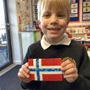 Children holding different flags made from hamma beads