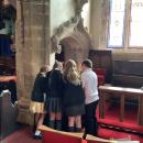 Children gathered around looking at the queens book of condolence 