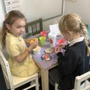 Girls playing in toy kitchen