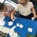 Class 3 pupils making number cards to work out the nrich maths problem