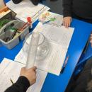 Child measuring and pouring water for a fair science test