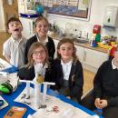 Stem challenge children with paper structures supporting an apple to replicate a skeleton