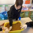 Children creating a model river in a tray 