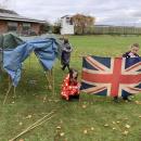 Girls setting up a flag outside their den