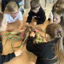 Class 3 pupils looking closely at some corn and discussing why it might be useful to the planet