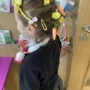 A child wwith chicks and eggs in their hair