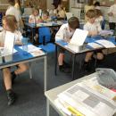Children are sitting at their desks in the classroom working.
