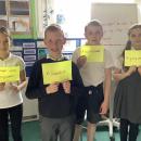 children standing in front of class with post it notes